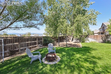 Fenced backyard with an outdoor fire pit and a patio area