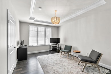 Sitting room with a tray ceiling, a chandelier, dark wood-style floors, an office area, and crown molding