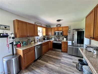 Kitchen featuring sink, stainless steel appliances, a textured ceiling, tasteful backsplash, and hardwood / wood-style floors