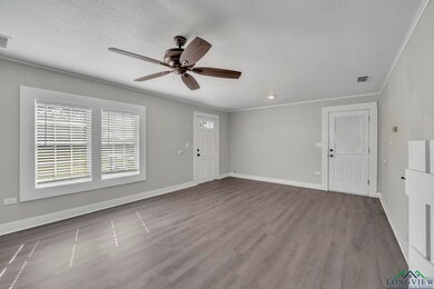 Entrance foyer with a ceiling fan, wood finished floors, a textured ceiling, crown molding, and baseboards
