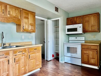Kitchen with sink, built in features, dark hardwoo