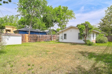 View of yard featuring fence, an outbuilding, and