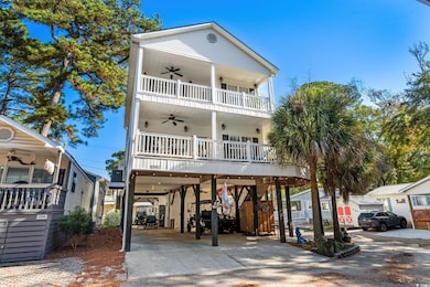 Coastal inspired home featuring ceiling fan, driveway, a carport, and stairs