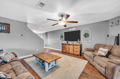 Living room with wood-type flooring and ceiling fa