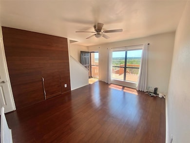 Empty room with a ceiling fan, dark wood finished