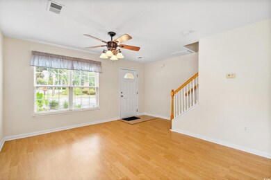 Foyer entrance with ceiling fan and light hardwood