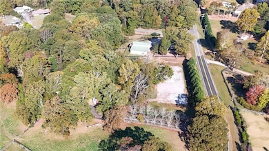 Aerial view of property and surrounding area with a heavily wooded area