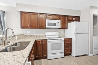Kitchen featuring white appliances, sink, light ha
