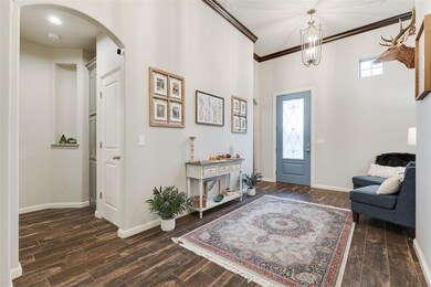 Foyer with arched walkways, baseboards, wood tiled