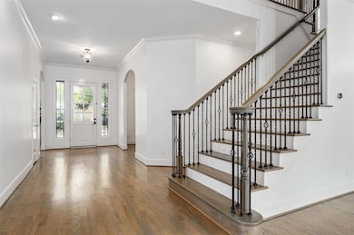 An alternate view of the entryway highlights the front door framed by side windows that fill the space with natural light. The first floor has been beautifully updated with modern finishes and design details.