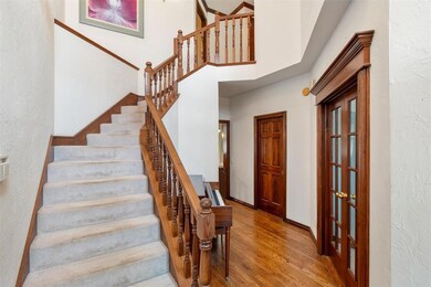 Entrance foyer with a high ceiling and hardwood / 