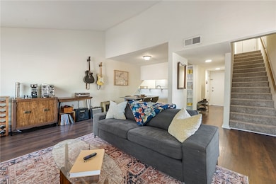 Living area featuring dark wood-style flooring and stairs