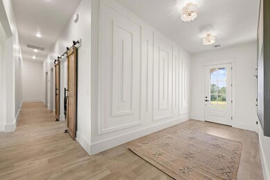 Entrance foyer with a barn door, light wood-type flooring, and recessed lighting