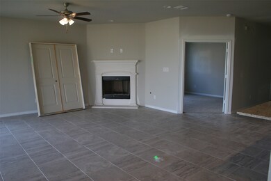 Family room with fireplace focal point and double door entry to the study to the right. (Excuse the construction supplies/doors currently in the room!)
