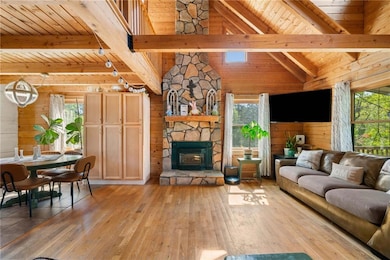 Living area with wood ceiling, wood walls, beamed 