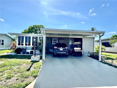 View of front of home with a carport and a front y