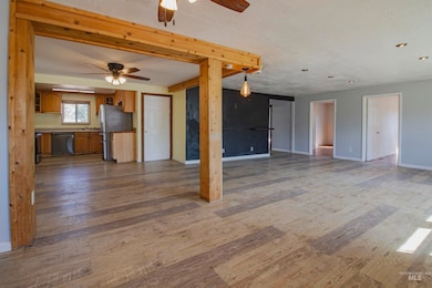 Unfurnished living room with dark wood-style floors, a textured ceiling, and ceiling fan