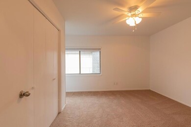 Unfurnished bedroom with baseboards, light carpet