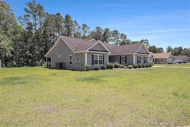 View of front of property featuring central AC, a front lawn, and roof with shingles