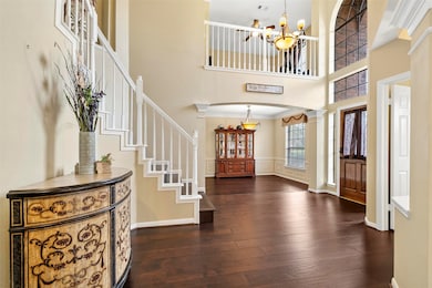 The grand entryway features soaring ceilings, designer mouldings, updated espresso-stained hardwood flooring. The formal dining room is located directly to the right, with the powder bathroom and formal living room/study option to the left.