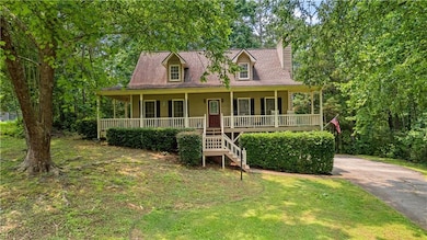 View of front of home with covered porch, stairs, a front yard, and concrete driveway