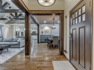 Foyer with wood-type flooring, ceiling fan, and beamed ceiling