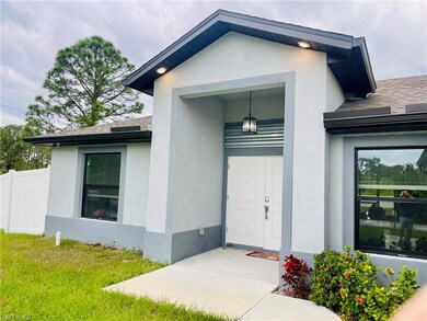View of exterior entry featuring stucco siding and a shingled roof