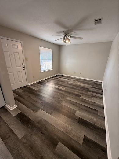 Entryway featuring a textured ceiling, a ceiling fan, and dark wood-style flooring