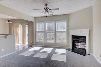 Unfurnished living room featuring ceiling fan with