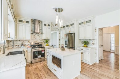 Kitchen with wall chimney exhaust hood, appliances