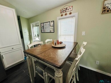 Dining space with dark wood-type flooring and baseboards