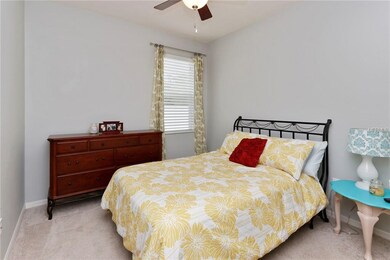 BEDROOM ONEWITH NEUTRAL CARPET AND CEILING FAN.