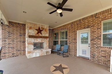 Oversized back patio with gorgeous stone gas fireplace.