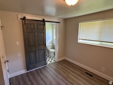 Foyer featuring dark wood-style flooring, a barn door, and a textured ceiling