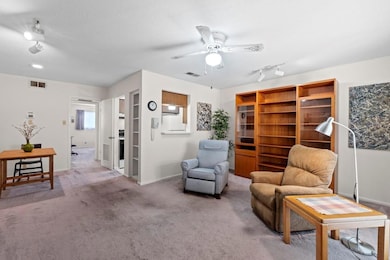 Sitting room featuring ceiling fan, carpet floori