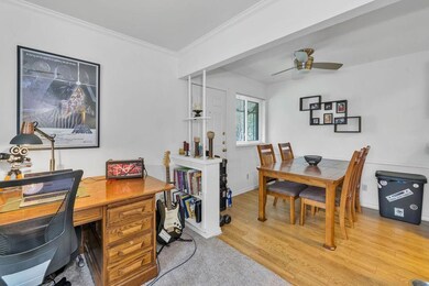 Home office with crown molding, ceiling fan, and w