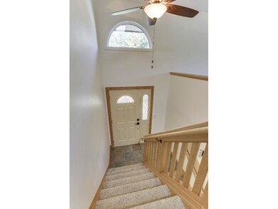 Entry has slate flooring, ceililng fan and wood ba