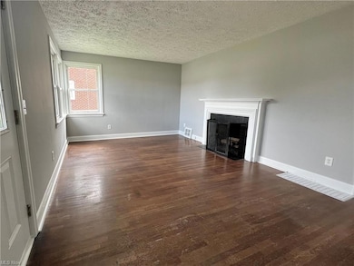 Living room with decorative fireplace and hardwood