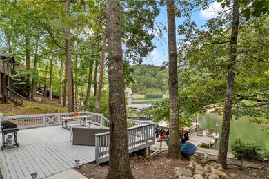 Wooden terrace featuring a water view and a grill