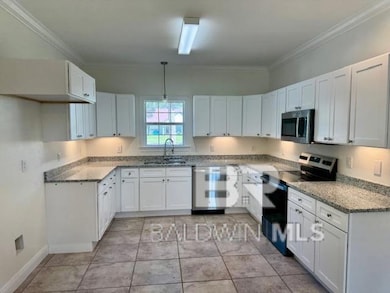 Kitchen featuring appliances with stainless steel finishes, new white cabinets, crown molding, and light stone counter tops
