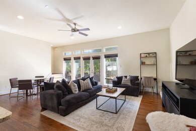 Living area featuring dark wood-style floors, recessed lighting, and ceiling fan