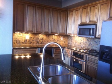 Kitchen with brown cabinetry, a sink, backsplash,