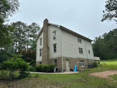 View of side of property with a chimney and a yard