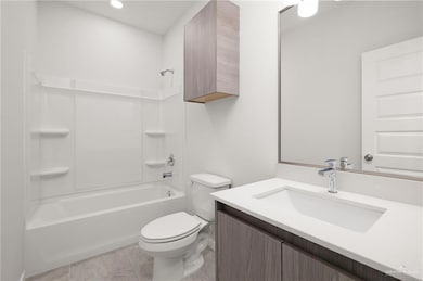 Bathroom with bathtub / shower combination, vanity, and light tile patterned floors