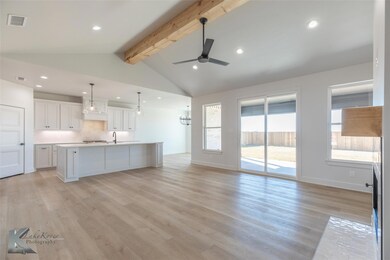 Kitchen with vaulted ceiling with beams, white cab
