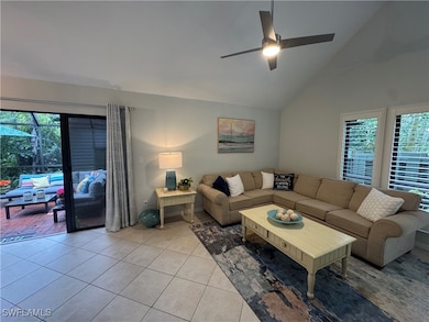Living room featuring ceiling fan, high vaulted ceiling, and lanai entry