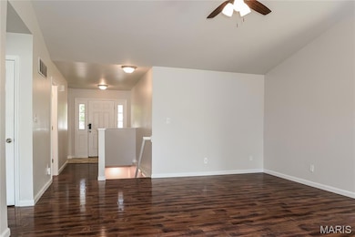 Entrance foyer with dark wood finished floors and a ceiling fan