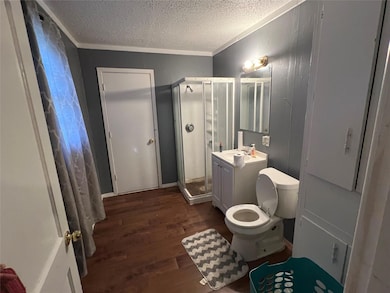 Bathroom with an enclosed shower, vanity, a textur