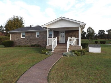 The circle drive leads to the inviting back entrance featuring a brick paved sidewalk & brick paved covered porch.