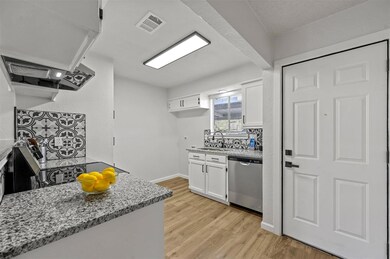 Kitchen with sink, light stone countertops, white 